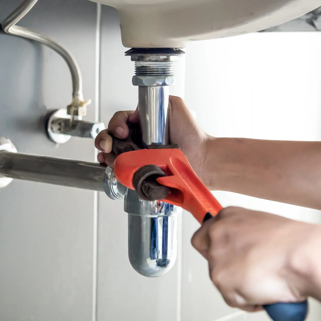 Plumber tightening pipe